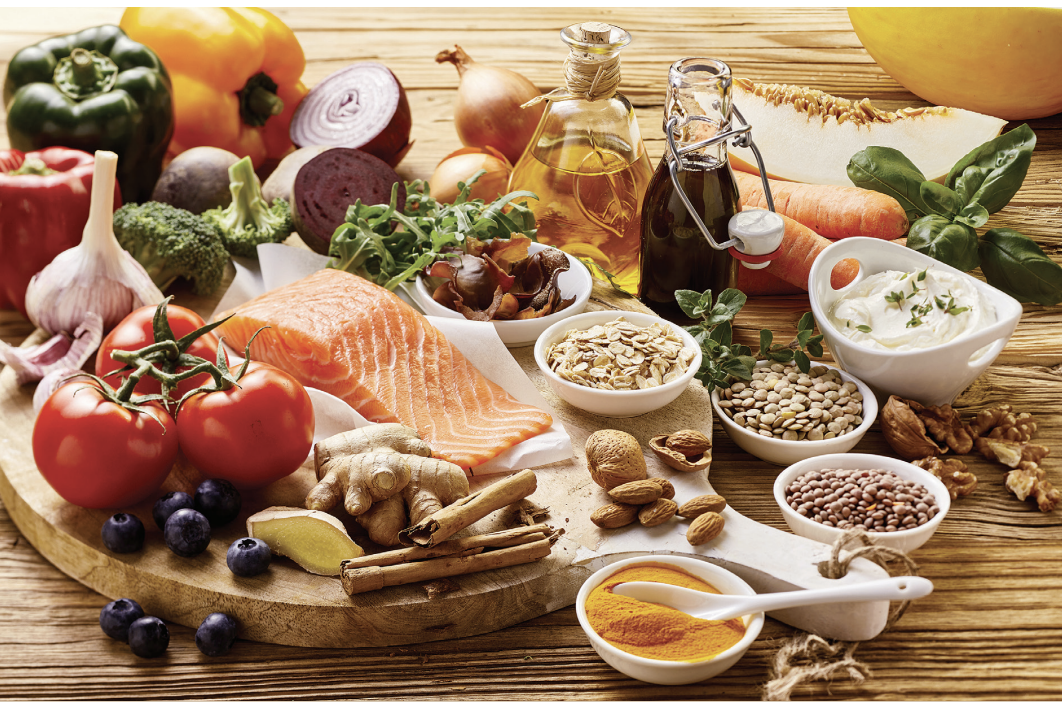 image of foods that are part of the Mediterranean diet, including nuts, seeds, bell peppers, olive oil, tomatoes, salmon