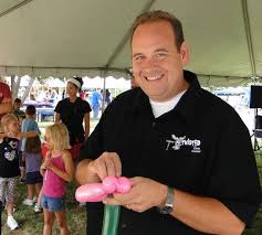 image is balloon artist Chris Conner twisting balloons