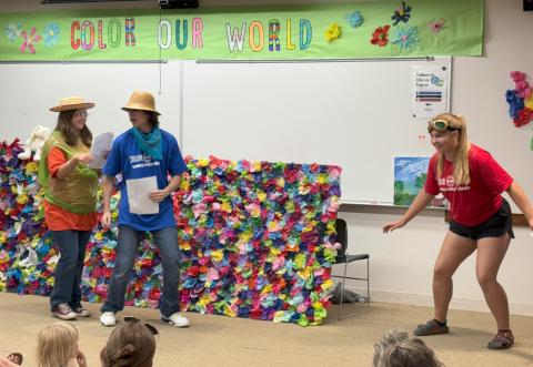 Picture includes 3 teen volunteers acting out the book "Little Blue Truck and Racer Red"