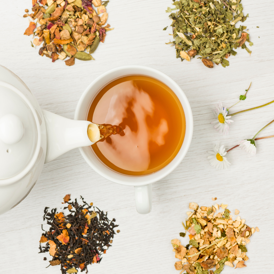 a cup of tea surrounded by a tea pot and a variety of dried teas